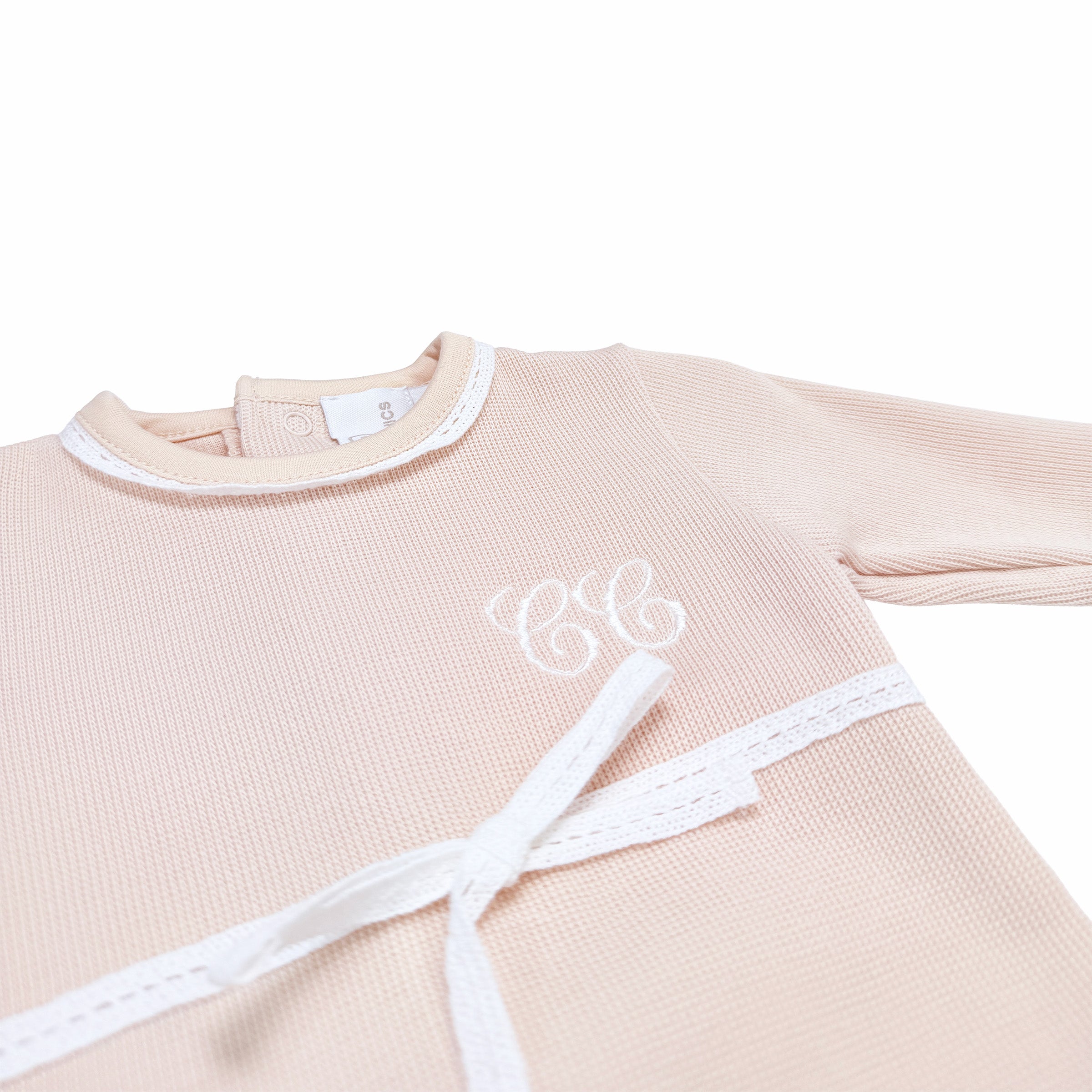 Close-up of London Embroidery on light beige special knit babygrow.