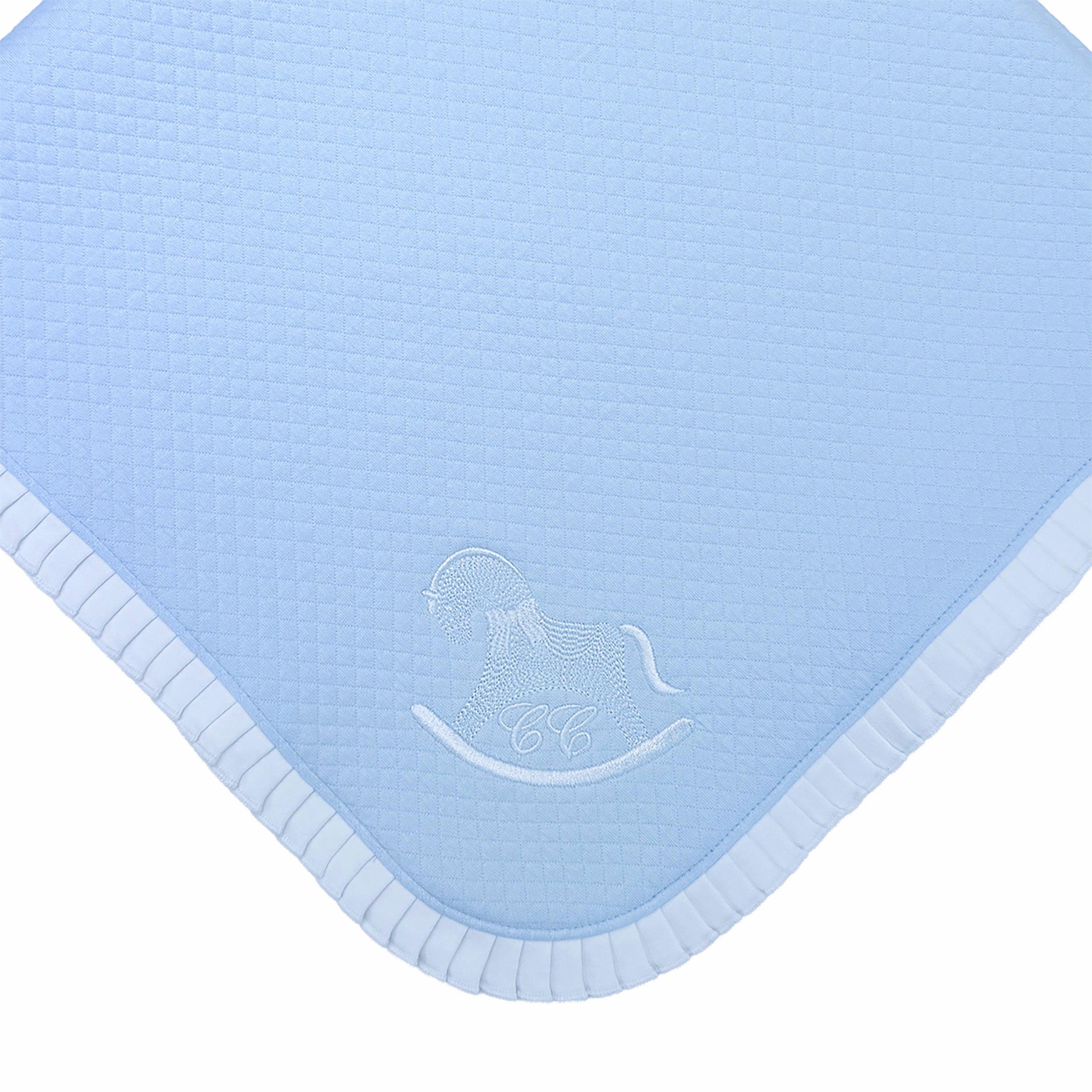 Close-up of frill border and embroidered motif on baby blanket.