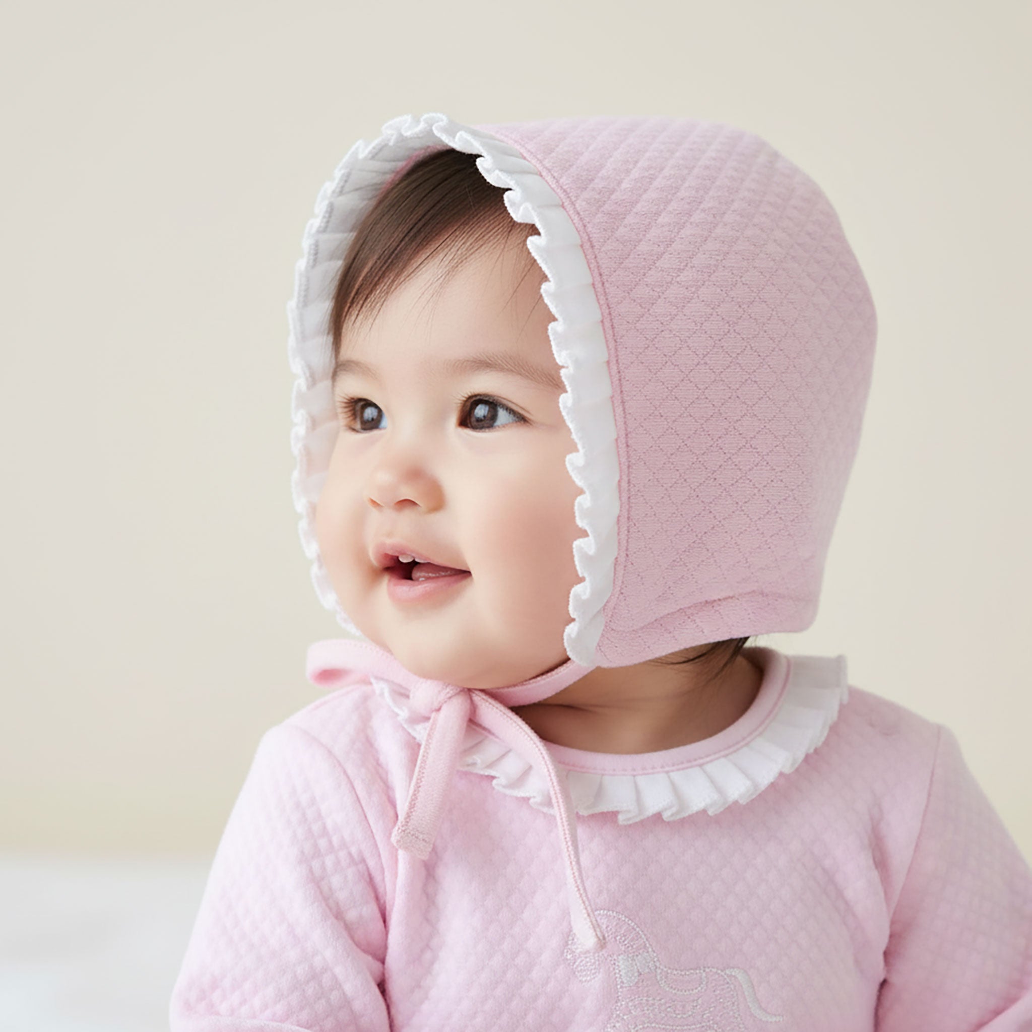 Baby girl wearing romance-style frilled bonnet – lifestyle