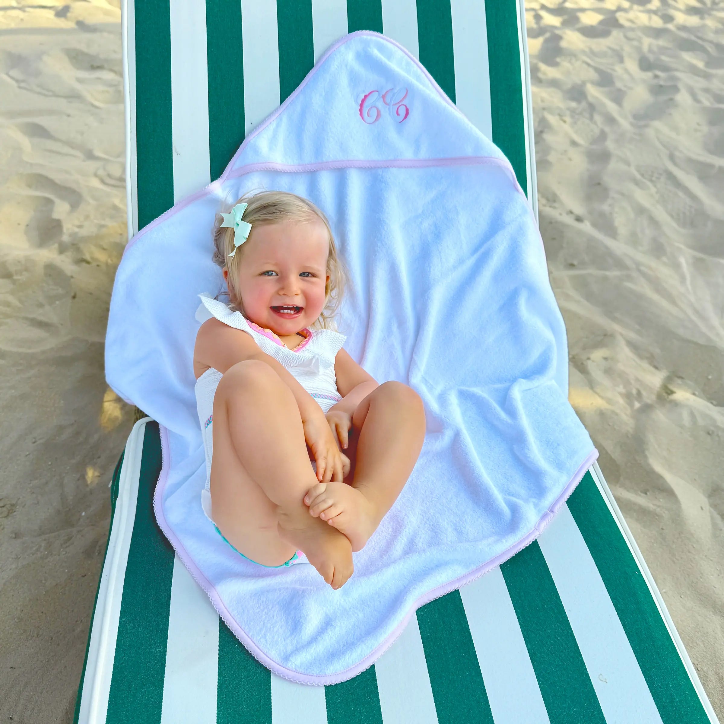 Baby girl is wrapped in luxury baby towel with embroidery and picot edge