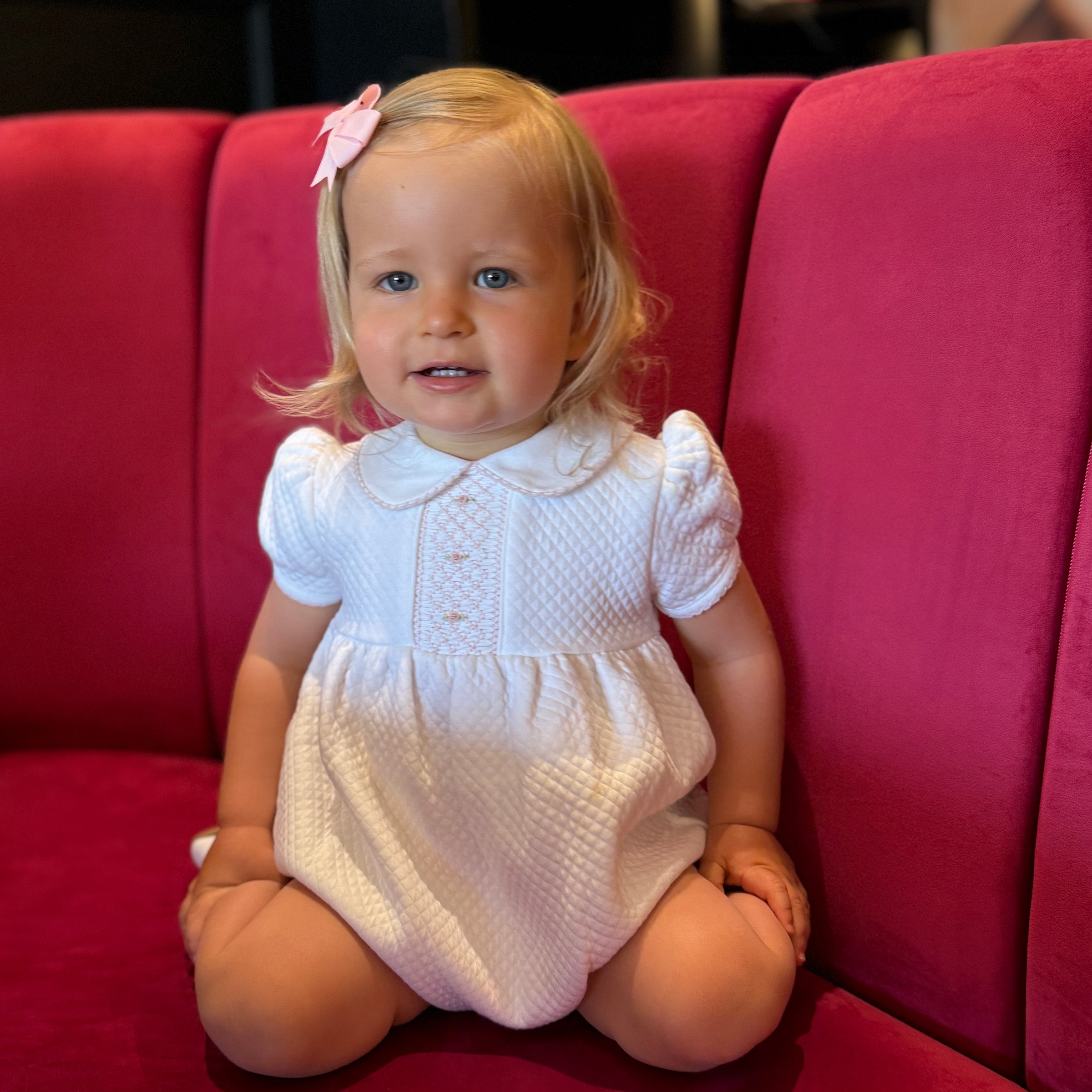 Baby girl is wearing Mademoiselle smocked romper with quilted texture