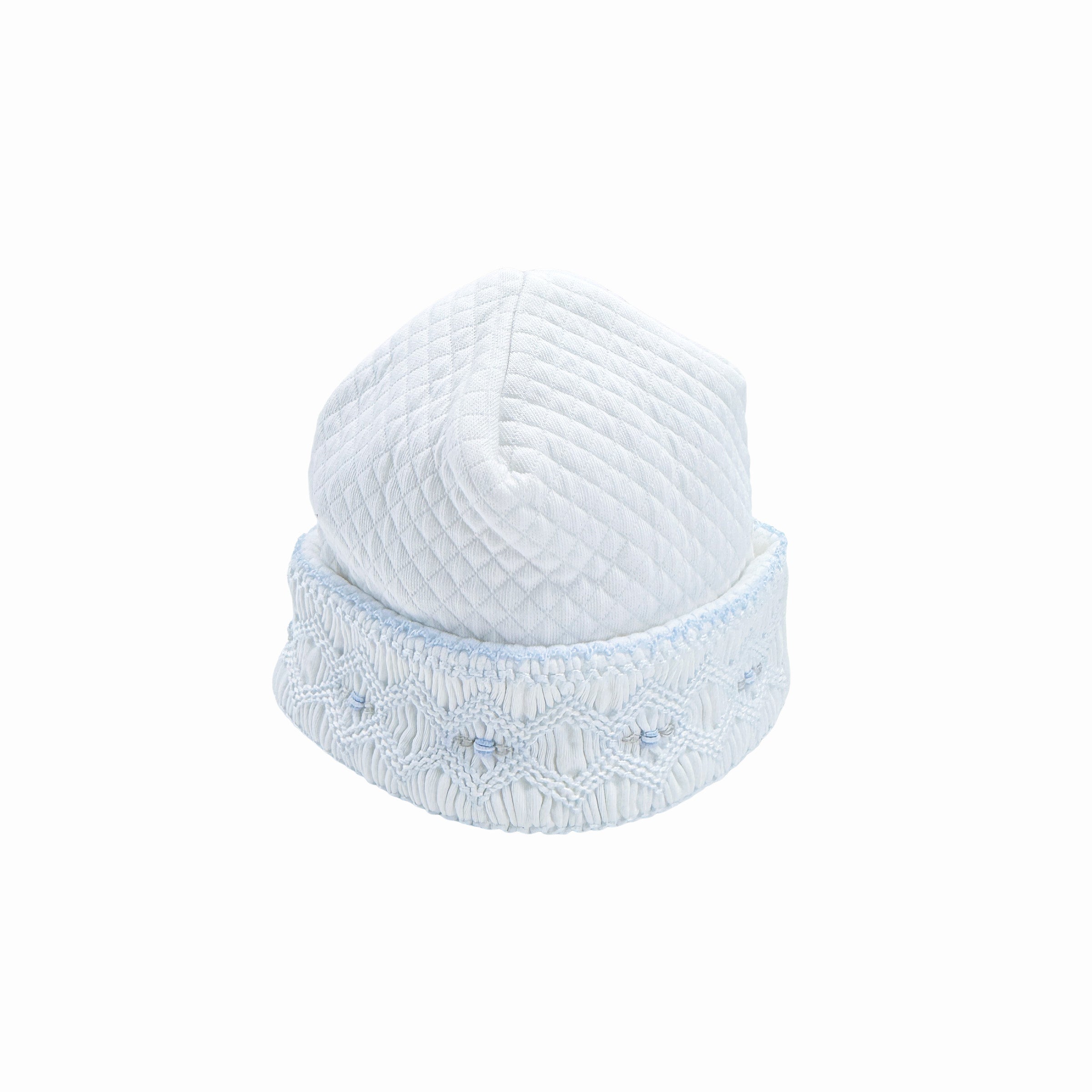 Close-up detail of blue smocked motif and quilting texture on the hat