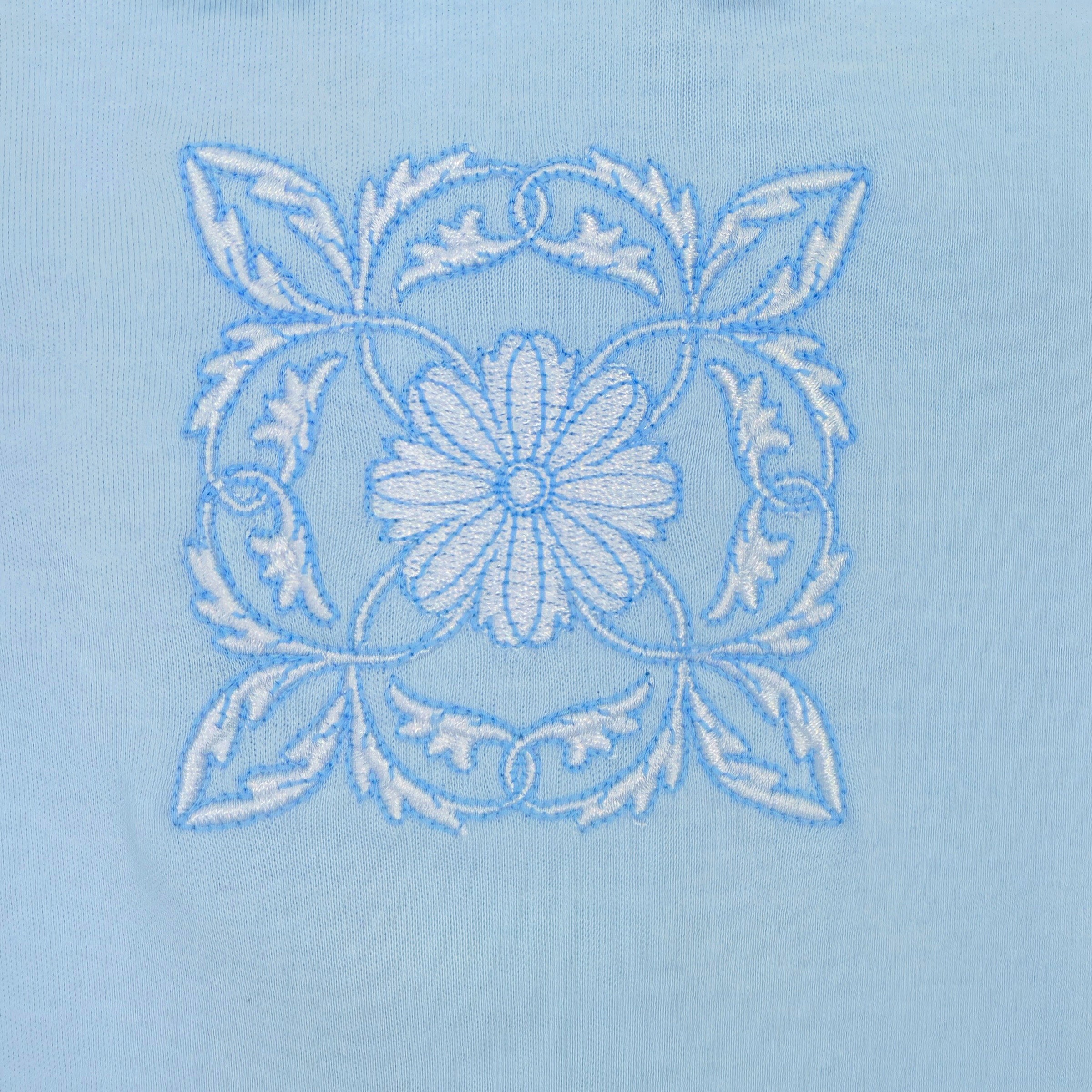 Close-up of intricate 16.8k-stitch embroidery on blue baby boy babygrow