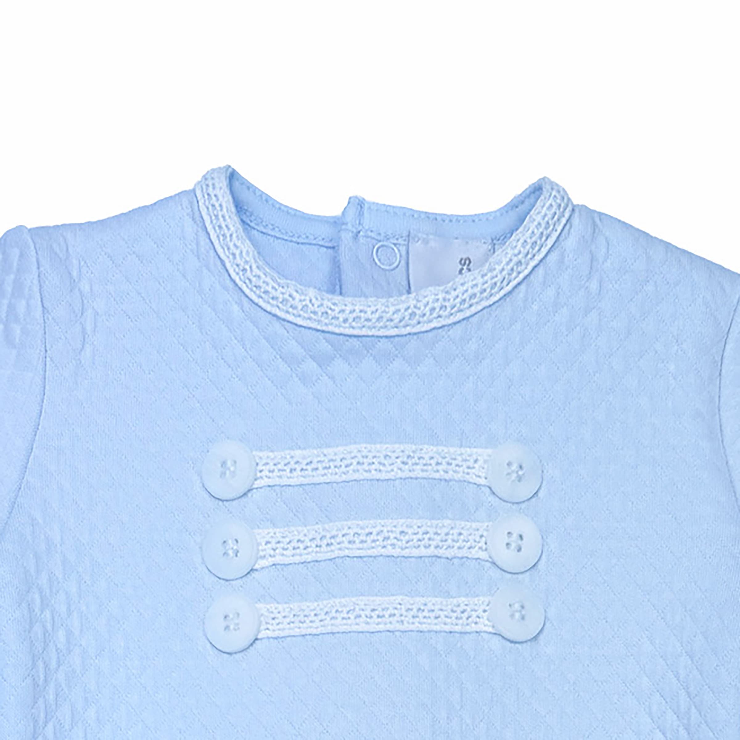 Close-up of trim and decorative button panel on baby boy babygrow